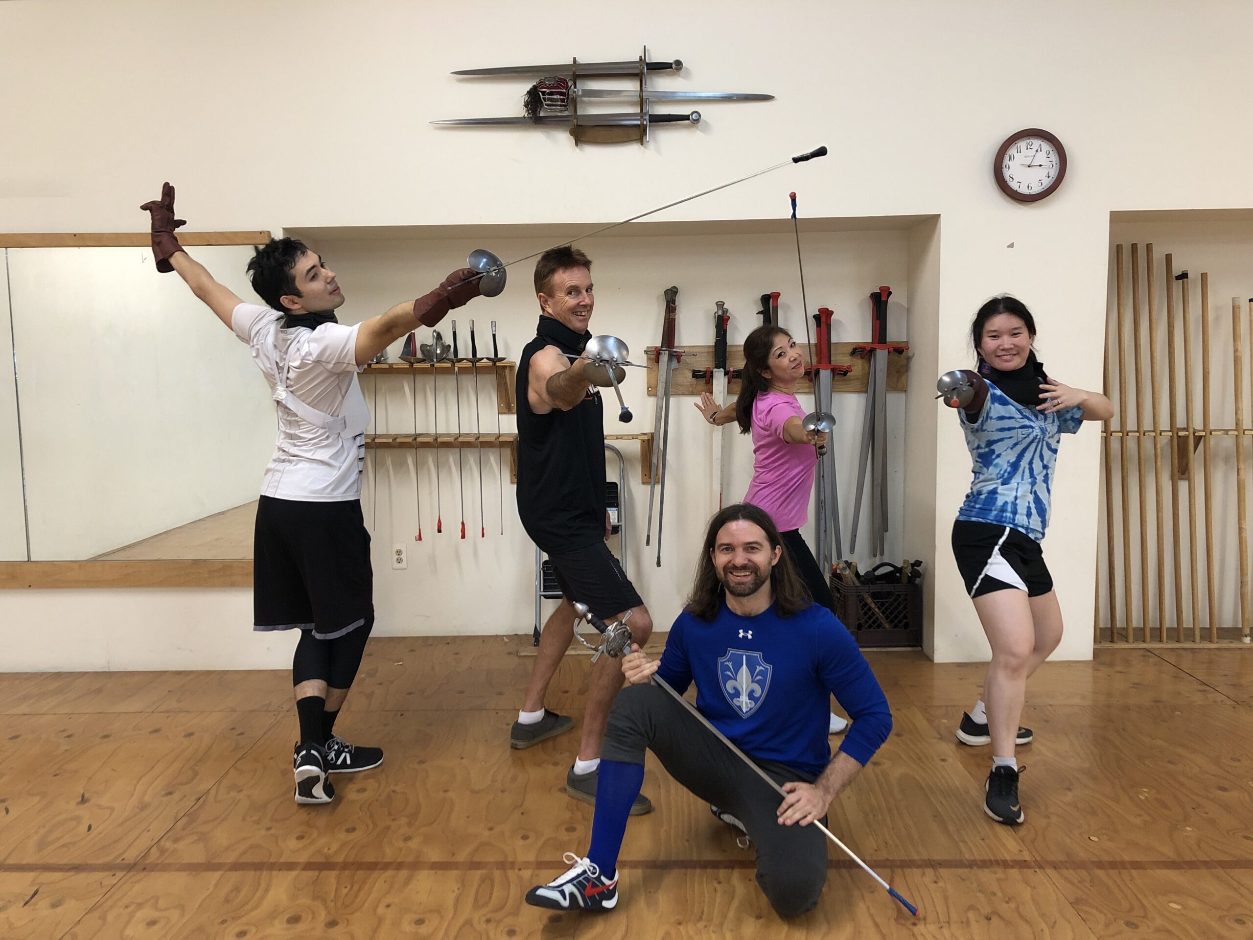 Group show of a family posing with rapier in various fencing postures at the end of an adventure program.