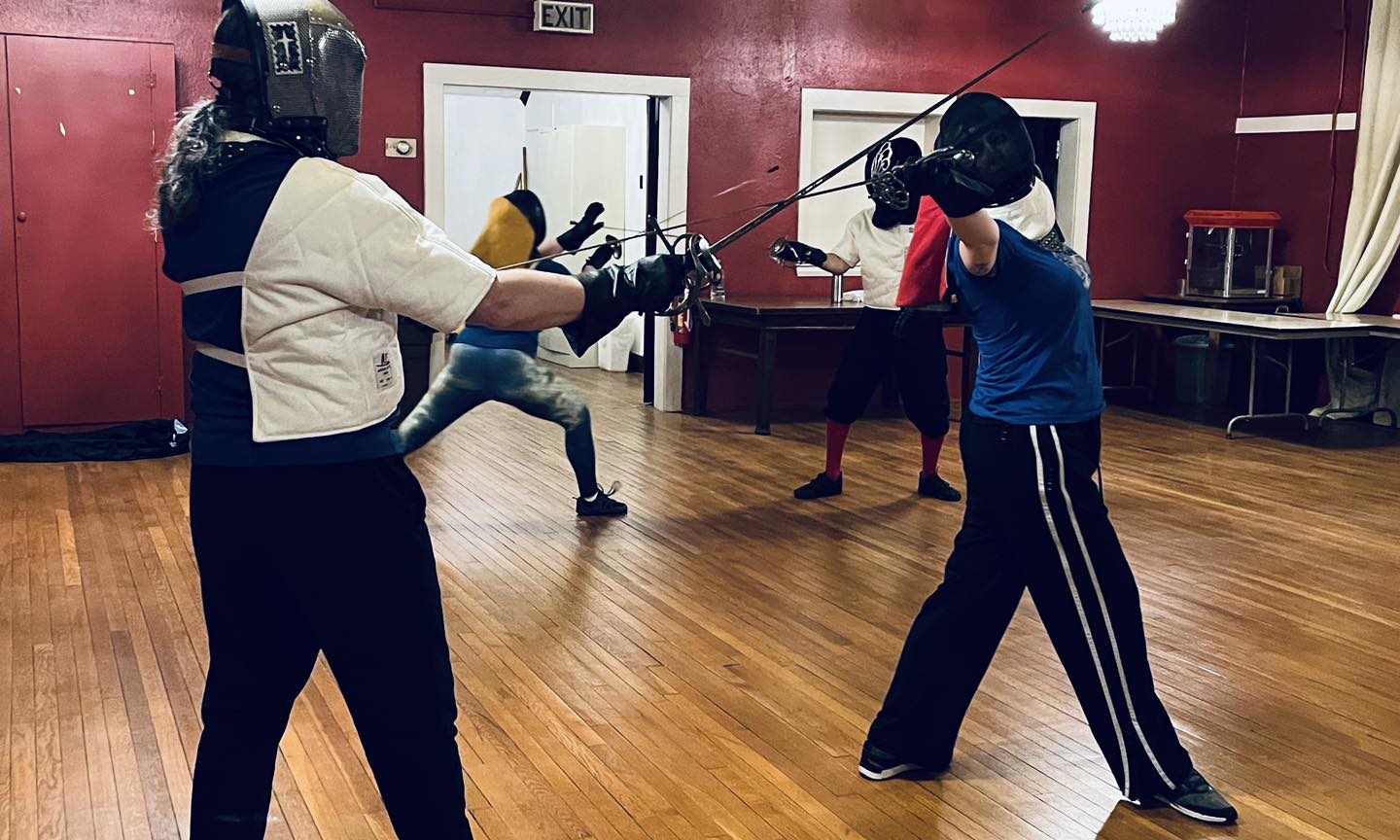 Woman historical rapier fencer performing a body void in class