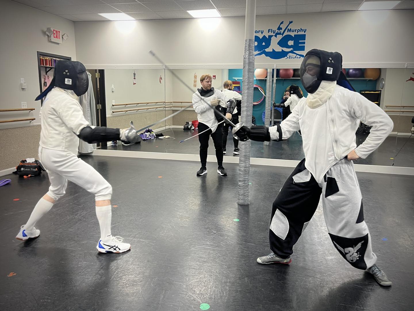 Two classical dueling saber fencers sparring in Somerville, MA