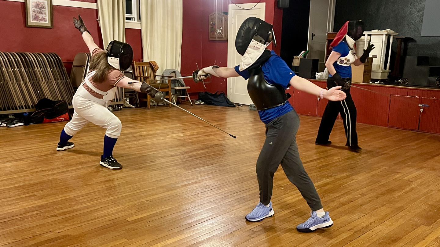 A beginner rapier fencer performs an arrest with reassemblement leg slip during training